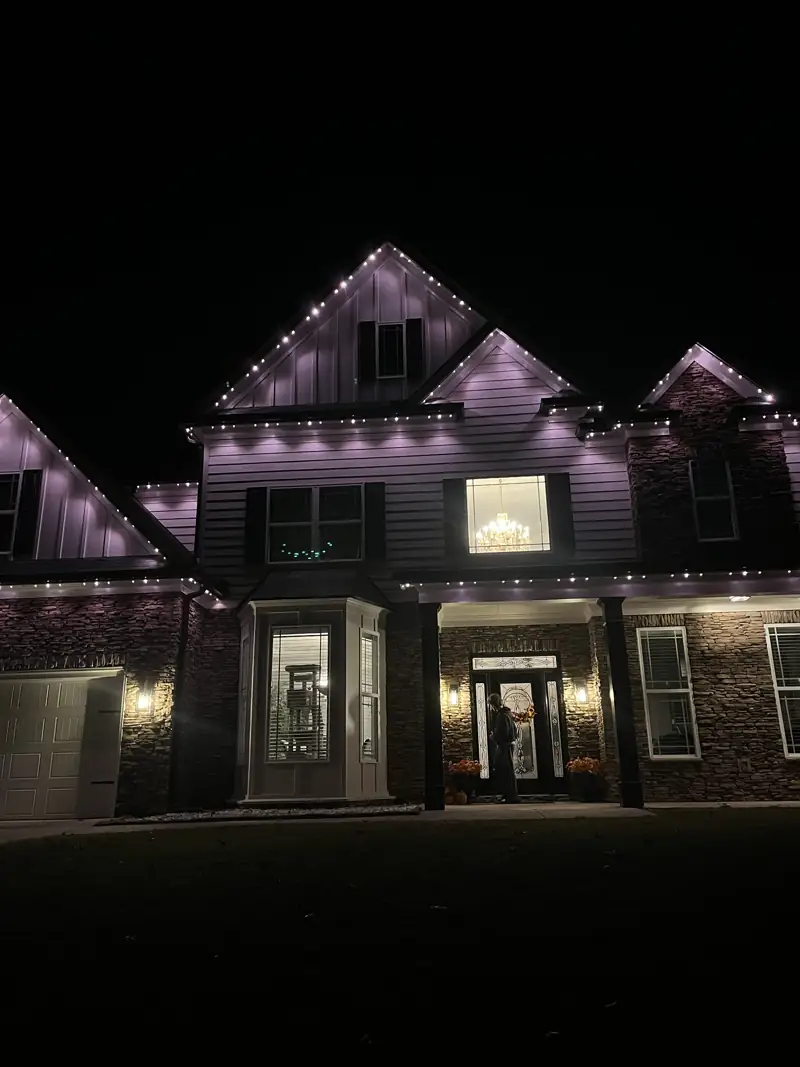 Home with purple permanent roofline lighting at night